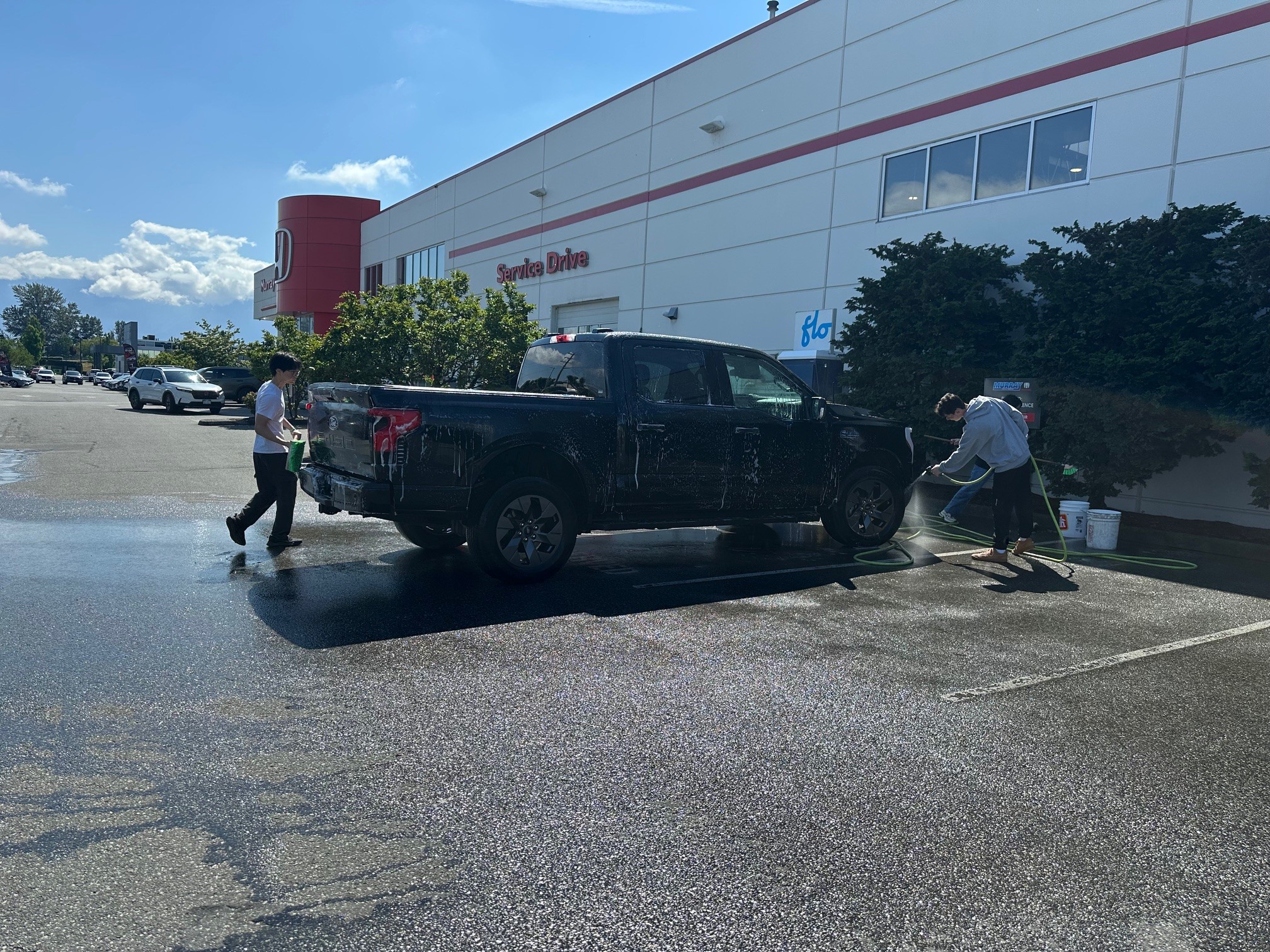 Students washing a truck at Murray Honda on a sunny spring day.